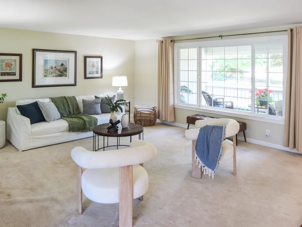 Bright and inviting living room featuring abundant natural light and a cozy seating arrangement.