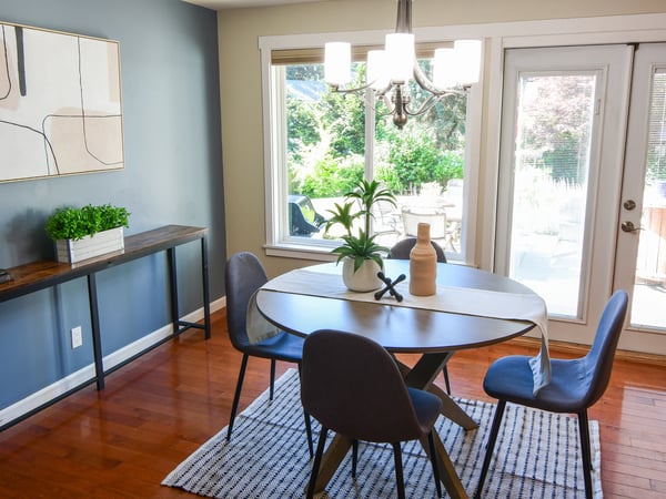 Bright dining area features large windows, contemporary decor, and direct access to an inviting outdoor space.