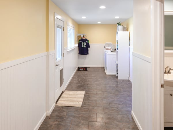 Bright and functional laundry room featuring ample space, modern appliances, and a convenient entryway.