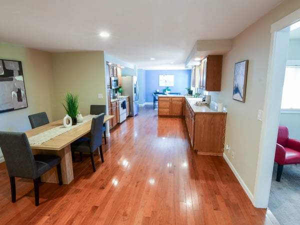 Spacious open-plan living area features gleaming hardwood floors and modern kitchen, perfect for entertaining.
