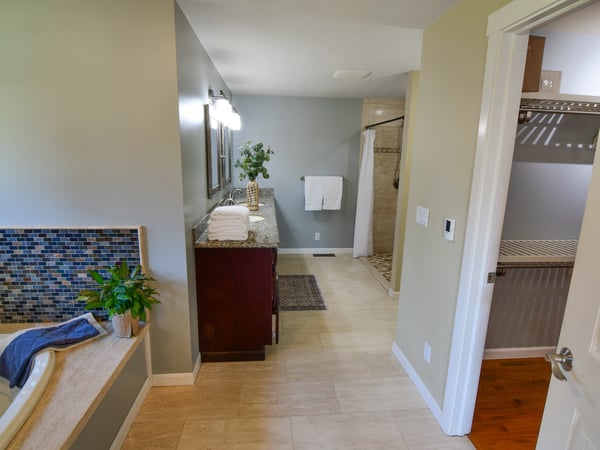 Modern bathroom featuring a spacious layout, dual vanities, and a separate shower area for added convenience.