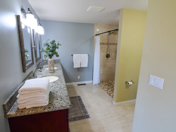 Spacious bathroom featuring a modern shower, ample countertop space, and natural light for a refreshing atmosphere.