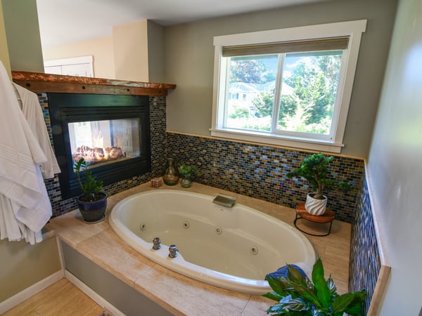 Experience relaxation in this inviting bathroom featuring a cozy fireplace and a spacious soaking tub.