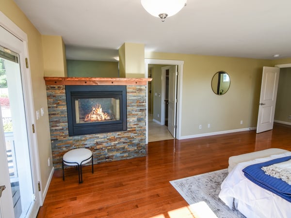 Bright and inviting living space featuring a modern fireplace and warm hardwood floors, perfect for relaxation.