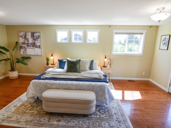 Bright and spacious bedroom featuring large windows, natural light, and direct access to outdoor space.