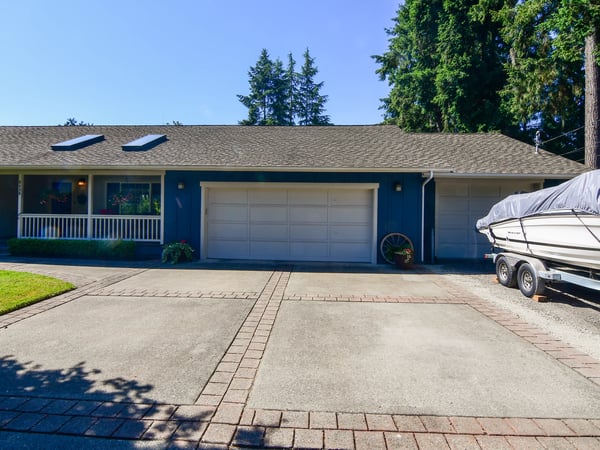 Spacious multi-car driveway leads to a welcoming home with boat storage and mature landscaping.