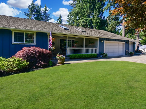 This inviting home features a spacious lawn, well-kept landscaping, and a welcoming porch in a tranquil setting.