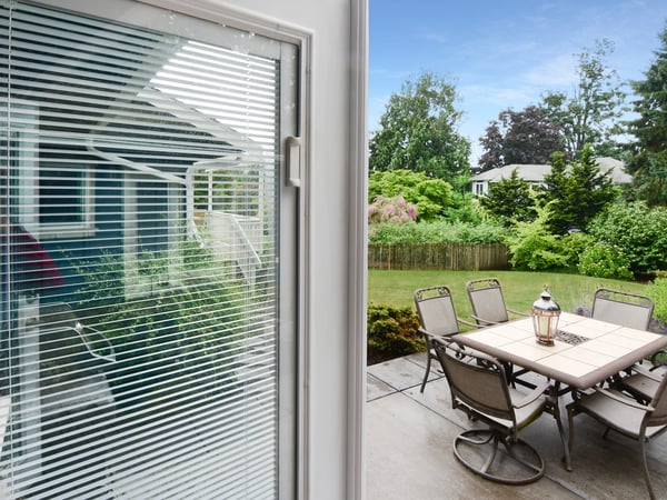 Spacious patio with modern furniture overlooks a lush, well-maintained garden, perfect for outdoor gatherings.