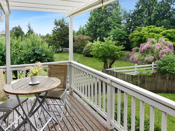 Enjoy al fresco dining on the spacious deck, overlooking a lush, vibrant green landscape and garden.