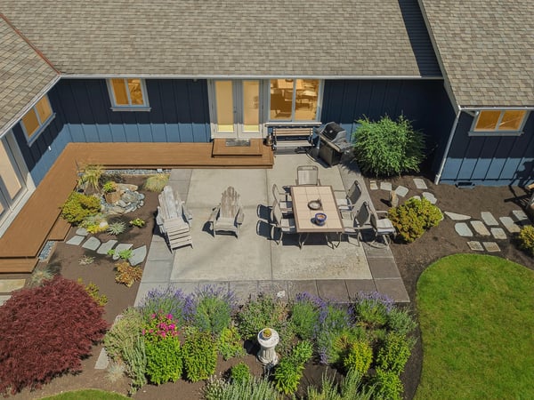 This inviting outdoor space features a spacious patio surrounded by vibrant landscaping, perfect for entertaining.