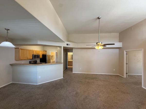 Open living room with vaulted ceilings, soft neutral finishes, and seamless connection to the kitchen. The spacious layout offers flexibility for entertaining and comfortable daily living.