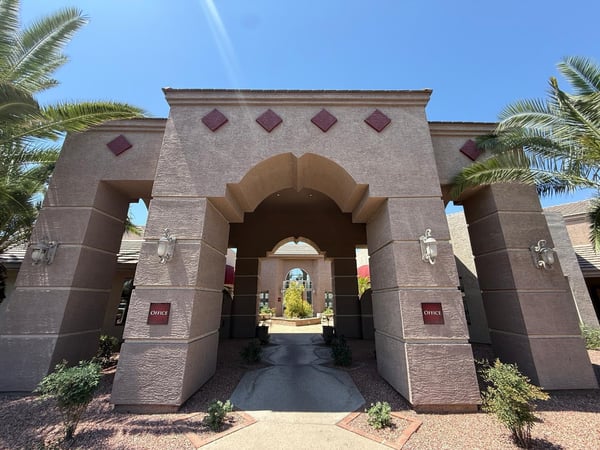 Architecturally striking clubhouse entrance framed by mature palm trees and attractive desert landscaping. This Phoenix community provides residents with access to appealing shared amenities and gathering spaces.