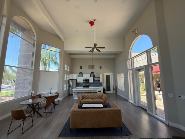 Spacious community lounge with dramatic architectural details, oversized windows, modern furnishings, and abundant natural light. Residents enjoy access to beautifully maintained amenities in Phoenix.