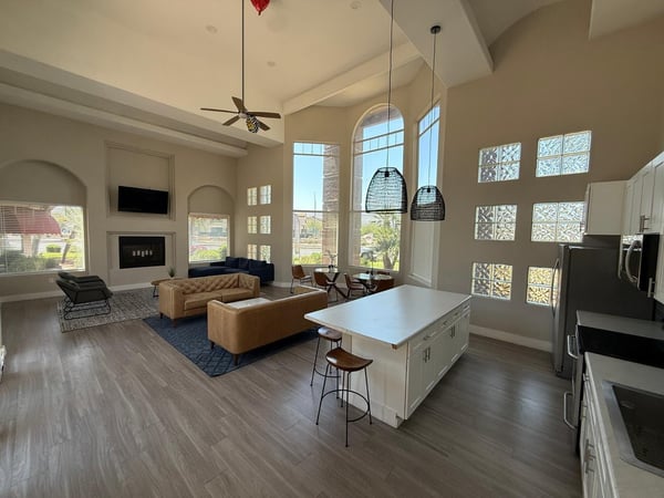 Expansive clubhouse great room showcasing a modern kitchen, oversized island, soaring ceilings, and bright gathering spaces. This impressive Phoenix community amenity offers exceptional versatility for residents and guests.