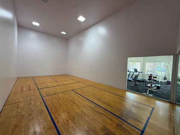 Indoor recreation court with hardwood flooring and generous dimensions for racquetball and other activities. Residents enjoy access to premium fitness and recreation amenities within this Phoenix community.