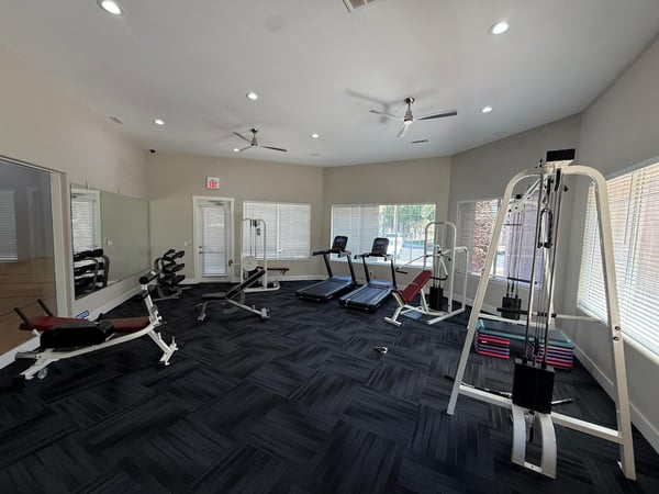 Community fitness room equipped with strength-training equipment, treadmills, free weights, and mirrored walls. An attractive Phoenix amenity that adds convenience and value to everyday living.