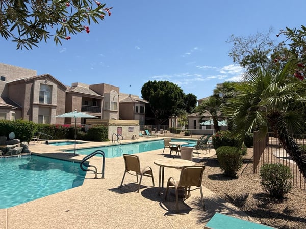 Scenic community pool area with sparkling water, lounge seating, mature landscaping, and inviting outdoor spaces. This Phoenix community amenity creates the perfect environment for relaxation and recreation.