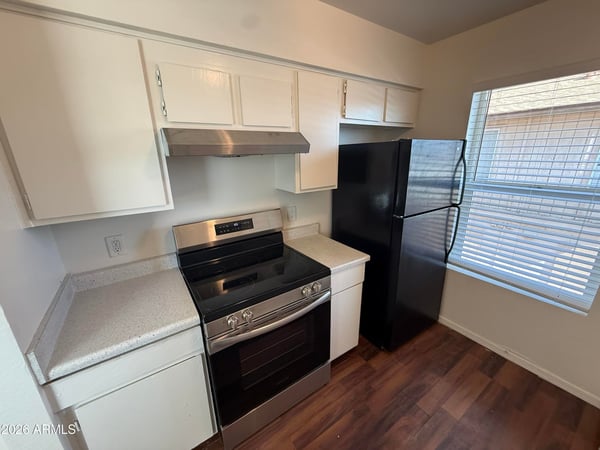 Kitchen highlights include updated black appliances, bright cabinetry, and easy-care countertops. The practical layout offers excellent workspace and storage for comfortable apartment living.