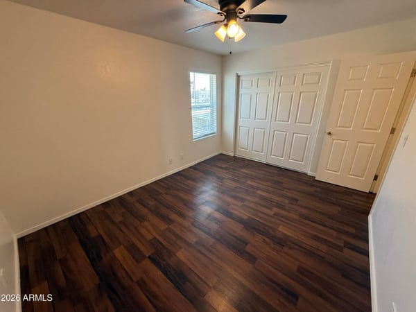 Spacious bedroom featuring a large closet, neutral finishes, and durable flooring. The room's generous proportions create a comfortable setting for a variety of furniture configurations.