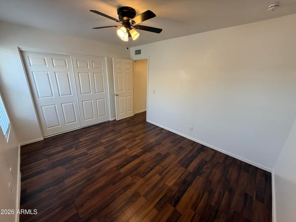 Well-appointed bedroom with ceiling fan, ample closet storage, and attractive flooring throughout. This comfortable space offers privacy and flexibility for residents seeking functional living areas.