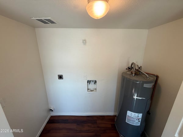 Interior utility room with washer and dryer hookups, dedicated laundry connections, and water heater access. This practical feature adds convenience and supports an efficient lifestyle.