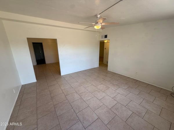 Generously sized living room with neutral finishes, ceiling fan, and durable tile flooring throughout. The open design creates a comfortable environment ideal for entertaining or everyday relaxation.