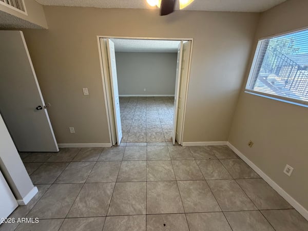 Flexible bedroom offering tile flooring, closet storage, and a ceiling fan for added comfort. This room easily accommodates sleeping quarters, office space, or a hobby room.