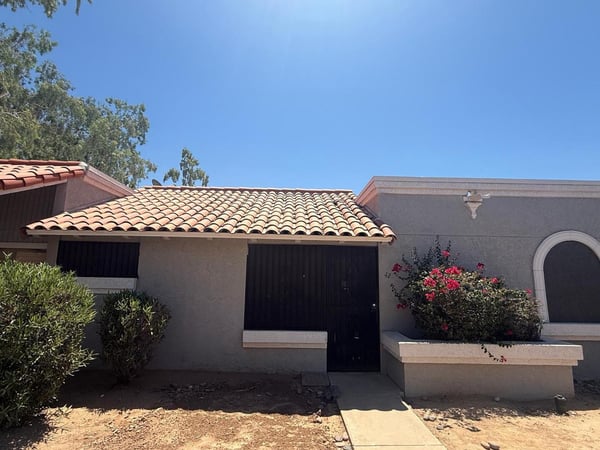 Attractive townhouse entrance with desert landscaping, tile roof accents, and private entry access. The welcoming exterior sets the stage for comfortable, low-maintenance living in a convenient Phoenix location.