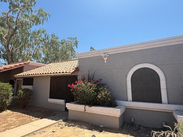 Exterior view highlighting classic Southwestern character, decorative architectural details, and mature landscaping. This appealing front elevation offers charm and easy upkeep for homeowners seeking convenience.