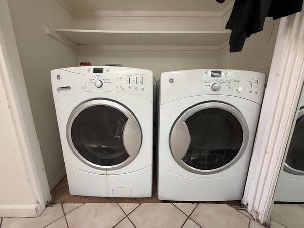 Dedicated indoor laundry space equipped with full-size washer and dryer. This