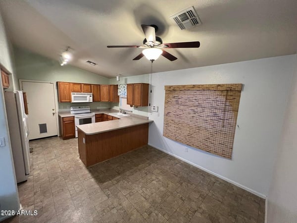 Functional kitchen featuring extensive cabinetry, a breakfast bar peninsula, and adjacent dining space. The thoughtful design allows easy interaction with guests while preparing meals.