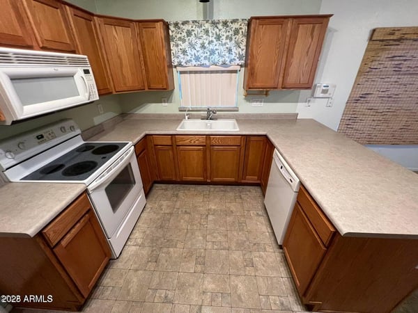 Well-organized kitchen featuring extensive countertops, plentiful cabinetry, and practical work areas. Ideal for meal preparation, hosting gatherings, and keeping everyday essentials within easy reach.