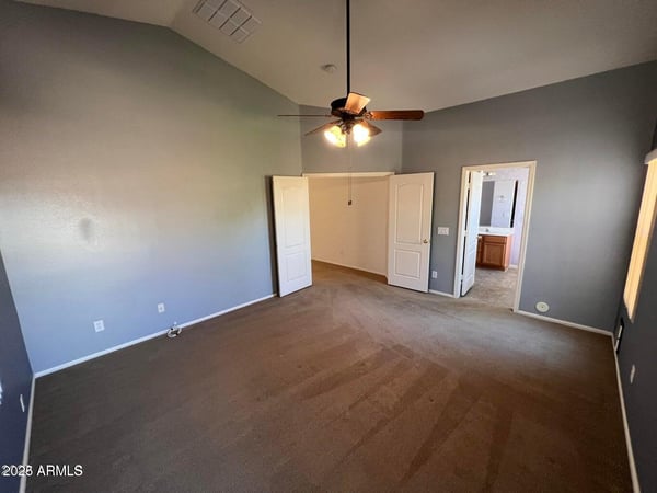 Well-designed primary suite with vaulted ceilings, neutral d cor, and convenient access to the ensuite bath. The open feel creates a relaxing environment ideal for everyday living.