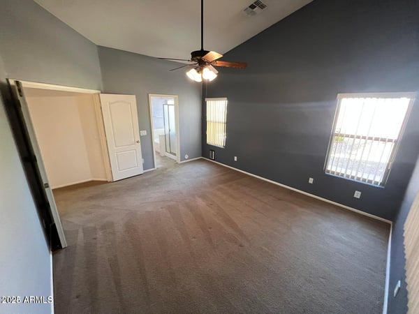 Comfortable primary bedroom featuring large windows, elevated ceilings, and generous square footage. A peaceful retreat designed to provide comfort and privacy.