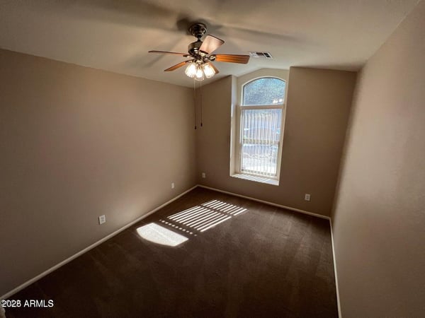 Flexible secondary bedroom with natural light, ceiling fan, and neutral finishes. Suitable for guests, family members, a home office, or additional living space in this inviting Goodyear home.