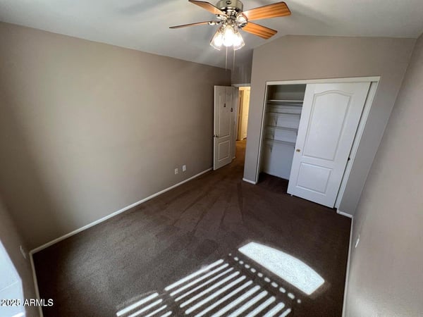 Inviting secondary bedroom with plush carpeting, ceiling fan, and neutral finishes. Natural light and a practical layout create a comfortable space for guests, family, or remote work.