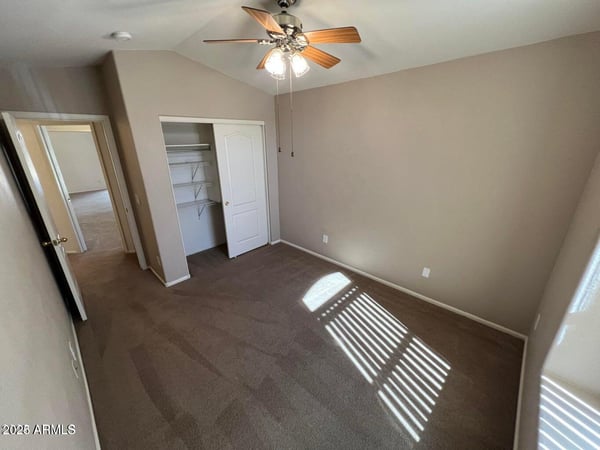Spacious bedroom featuring a large closet, soft neutral tones, and ceiling fan. This versatile room offers flexibility for sleeping quarters, a hobby room, or a dedicated office space.
