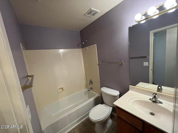 Full bathroom featuring a tub and shower combination, vanity storage, and easy-care finishes. Designed to comfortably accommodate guests and everyday household use.