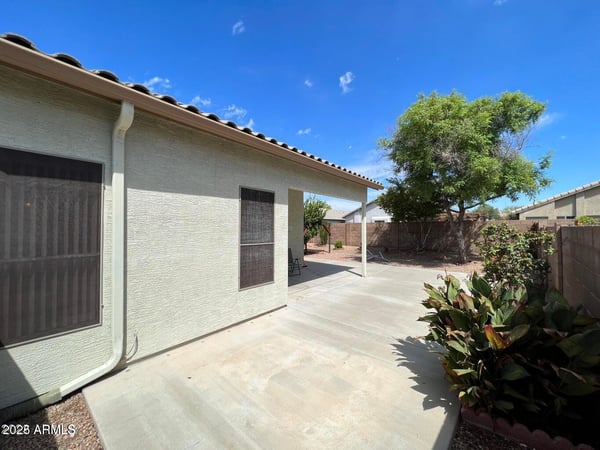 Large patio area overlooking the landscaped backyard with mature trees and low-maintenance grounds. This outdoor living space offers the perfect setting for dining, entertaining, and enjoying the Arizona lifestyle in a desirable Goodyear location.