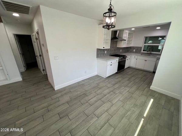 Enjoy easy entertaining with this open dining space situated next to the remodeled kitchen. Updated lighting and stylish flooring create a polished and inviting atmosphere.