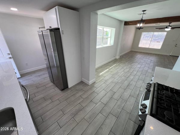 The open floor plan creates an effortless flow between the remodeled kitchen and living spaces. Quartz countertops, stainless steel appliances, and modern flooring contribute to the home's contemporary appeal.