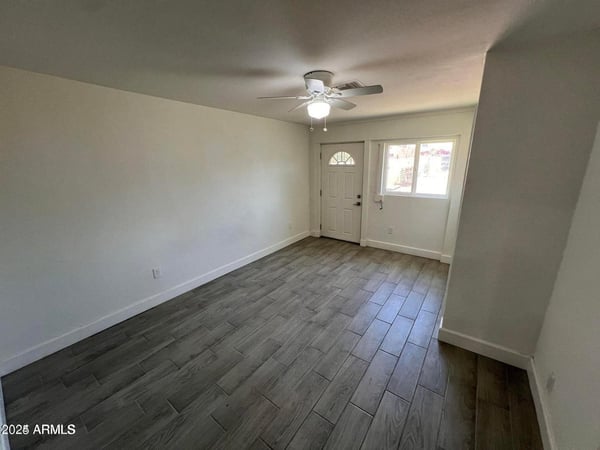 This primary bedroom offers a comfortable layout with updated finishes, ample natural light, and a ceiling fan. The room provides a relaxing private space within this beautifully remodeled home.