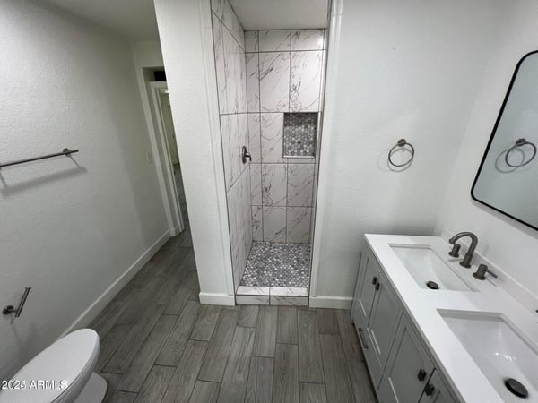 Contemporary finishes define this updated bathroom, highlighted by a spacious walk-in shower, dual vanity, and modern fixtures. The thoughtful design balances comfort and sophistication.