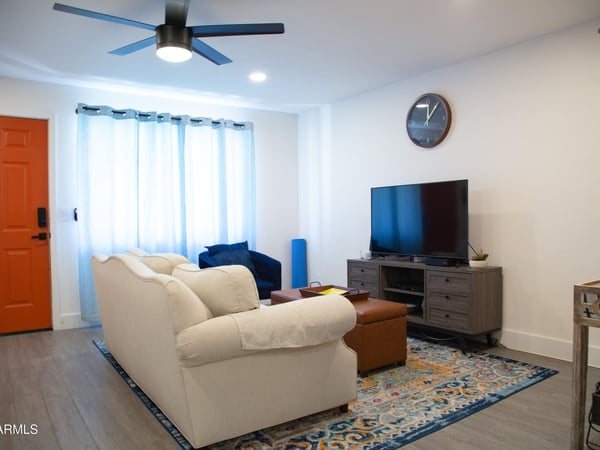 This beautifully updated living room offers modern flooring, fresh finishes, and flexible furniture arrangements. The open design enhances natural flow throughout the home and creates an inviting environment.