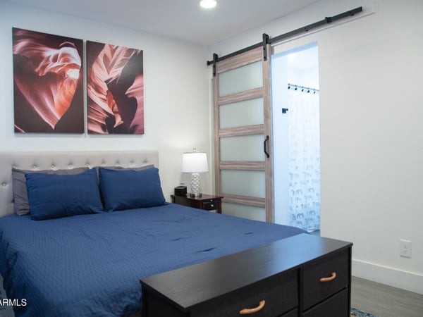 Featuring updated flooring, contemporary d cor, and a stylish barn door, this bedroom blends comfort and functionality. The thoughtfully remodeled interior creates a move-in-ready living experience.