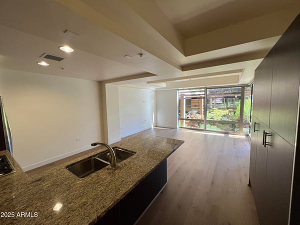 Open living and kitchen area featuring granite surfaces, stainless steel appliances, and abundant natural light. A thoughtfully designed space ideal for entertaining and everyday living.