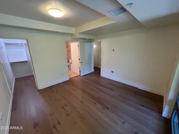 Private primary suite with warm finishes, natural light, and ample space for furnishings. The adjoining walk-in closet and ensuite bath create a comfortable retreat within the home.