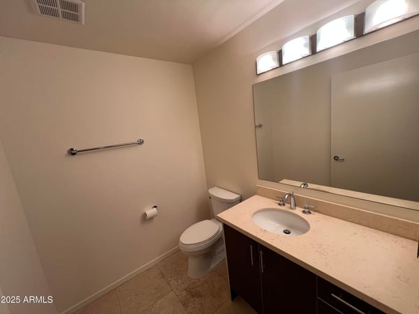 Convenient guest bathroom featuring contemporary cabinetry, stone countertops, and modern fixtures. A clean and functional space that complements the home's upscale interior finishes.