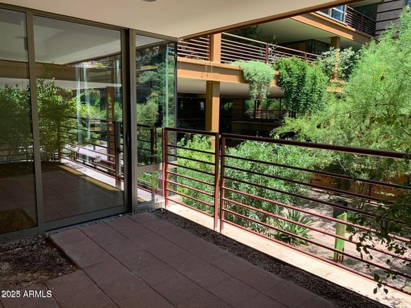 Covered patio offering private outdoor living space with views of lush landscaping and architectural details. Perfect for morning coffee, entertaining guests, or enjoying the surrounding scenery.