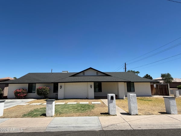 Beautiful front elevation highlighted by a covered entry, flowering shrubs, and clean desert-friendly landscaping. This move-in-ready home offers timeless style and convenience.